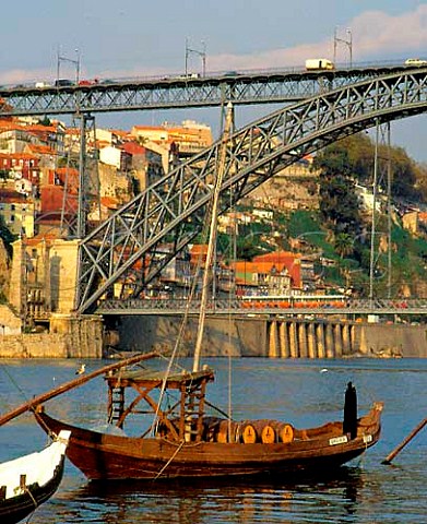Barcos rabelos moored on the Douro by Eiffels Ponte   de Dom Luis I which spans the river from Vila Nova   de Gaia to Porto Portugal