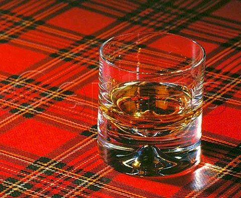 Tumbler of malt whisky on tartan