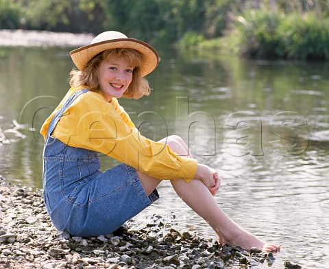Young woman 16 sitting by river 