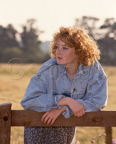 Young woman 16 leaning on stile