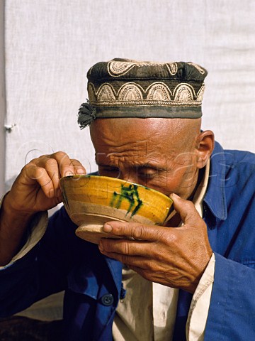Man eating a bowl of noodles in Kashgar Sunday Market  Xinjiang Province China