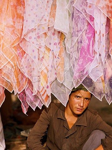 Man selling head scarves at Kashgar Sunday Market  Xinjiang Province China