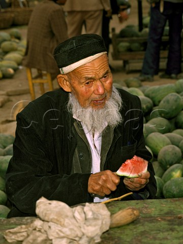 Man cutting a water melon Turfan Market Xinjiang Province China