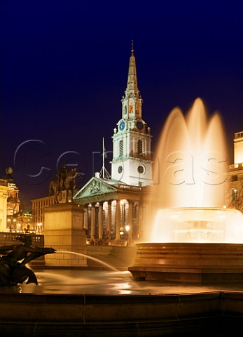 Fountains in Trafalgar Square at night with the spire of StMartinsintheFields behind London