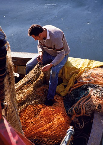Fisherman tending his nets  Sutton Harbour Plymouth  Devon England