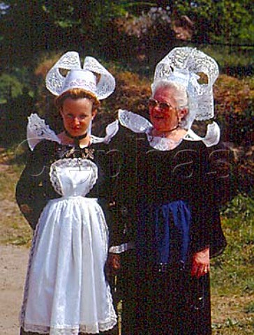 Women wearing traditional Breton Coiffe and   costumes Left Coiffe of Pont Aven Right Coiffe   of Quimperle Both made from starched lace    Pardon of Lothea near Quimperle Finistre France    Brittany