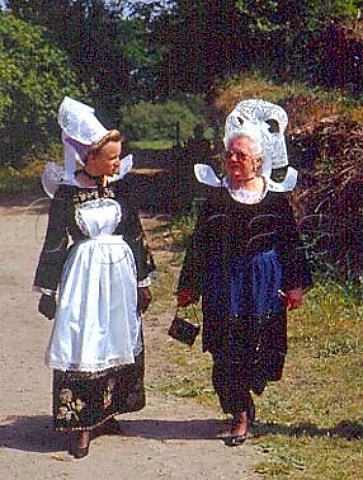 Women wearing traditional Breton Coiffe and   costumes Left Coiffe of Pont Aven Right Coiffe of   Quimperle Both made from starched lace    Pardon of Lothea near Quimperle Finistre France    Brittany