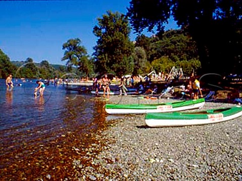 Tourist canoes on the bank of the Dordogne River at  Domme Dordogne France