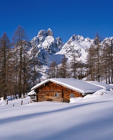Alpine hut at foot of Bischofmutze mountain in winter Salzburgerland Austria