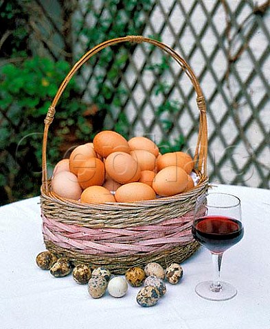Basket of eggs with quails eggs and glass of red   wine