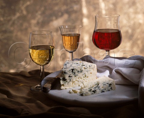 Glasses of red white and sweet wine with Roquefort cheese