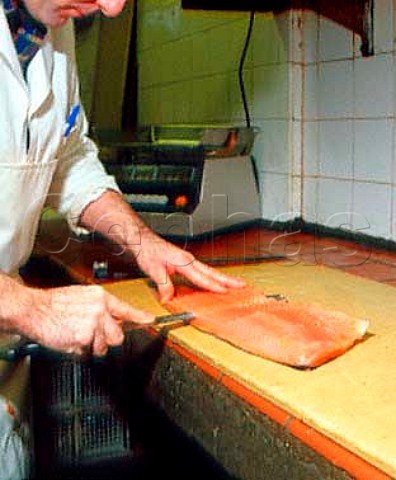 Hand slicing of sides of smoked salmon at AHJarvis  and Sons Kingston upon Thames Surrey