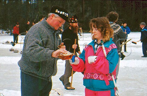 Keeping warm with a dram of Scotch at an   outdoor curling contest Grantown on   Spey Scotland