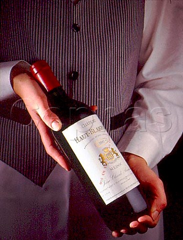 Sommelier holding bottle of Chteau HautBlaignan   1985 Mdoc  Bordeaux