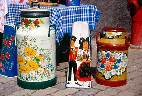 Colourful painted items milk churns and coal scuttles  Alsace France