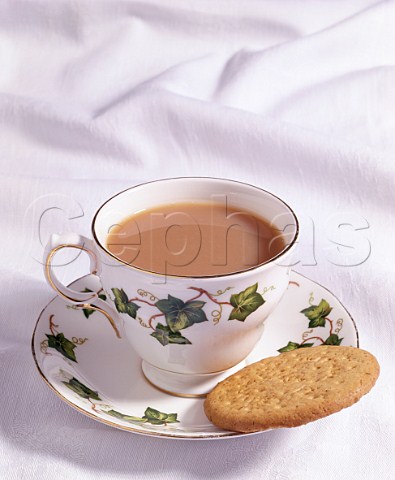 Cup of tea with milk and a digestive biscuit