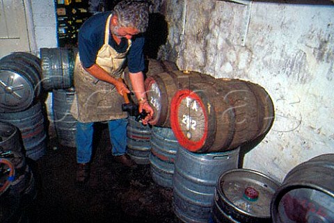 Tapping wooden beer barrels in public   house cellar