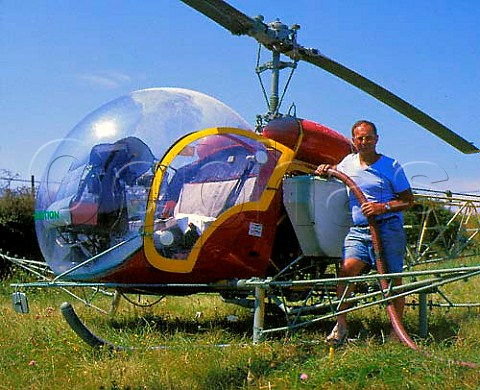 Filling the tanks attached to the sides of   helicopter ready for spraying of a vineyard on the   CteRotie Rhne France