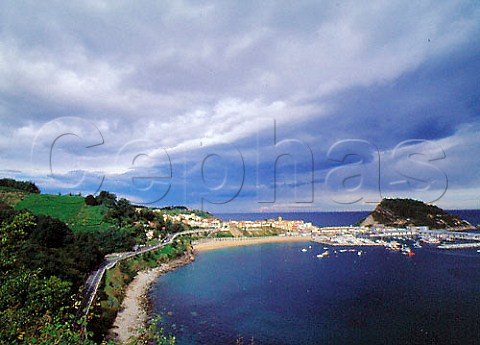 The fishing port of Guetaria overlooked by vineyards   on the hill above Guipzcoa Spain  DO Chacol de Guetaria
