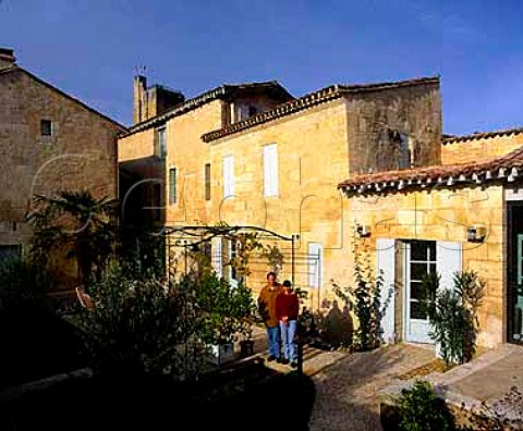 JeanLuc and Muriel Thunevin of Chteau de Valandraud in the garden of their house in the centre of Stmilion The 12th century Kings Tower can be seen behind Stmilion Gironde France