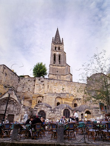 Lunchtime diners in the square of Stmilion below  the church and belltower   Gironde France
