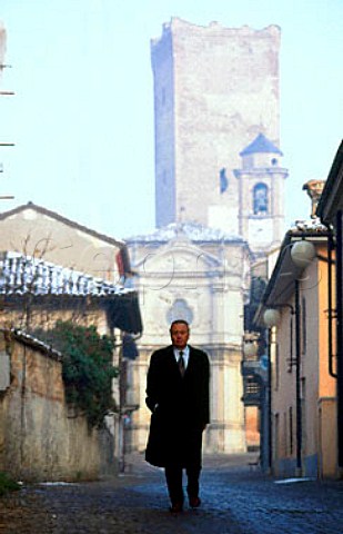 Angelo Gaja walking down the main street   of Barbaresco with the castle tower   behind him Piemonte Italy
