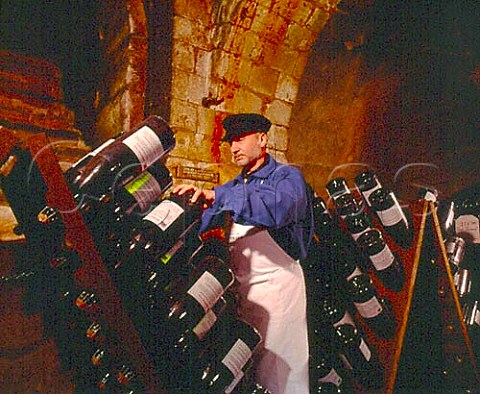 JeanPierre Girondin Chef de Caves working   on Jeroboams in pupitres in the remains of the   13th century chapel of Saint Niaise Abbey   which form part of the cellars of   Champagne Taittinger Reims Marne France