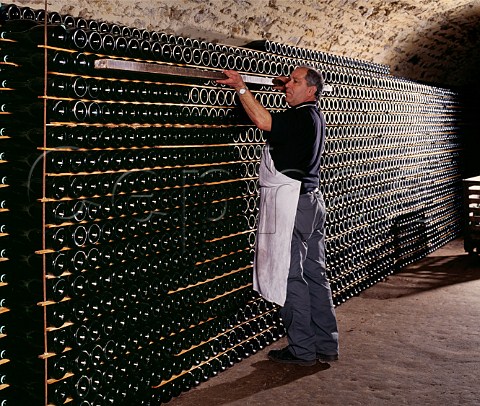 Using a piece of wood to align bottles which have been stacked to age sur lattes  Champagne Salon Le MesnilsurOger Marne France   Cte des Blancs  Champagne