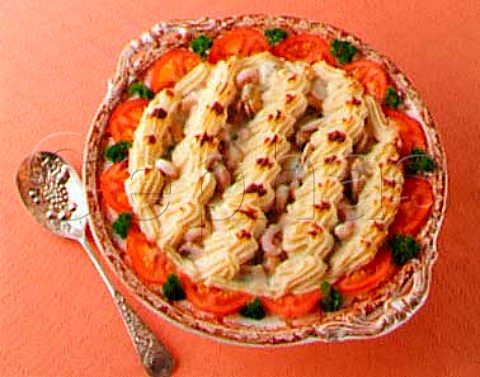 Fish and seafood pie with tomato and parsley garnish