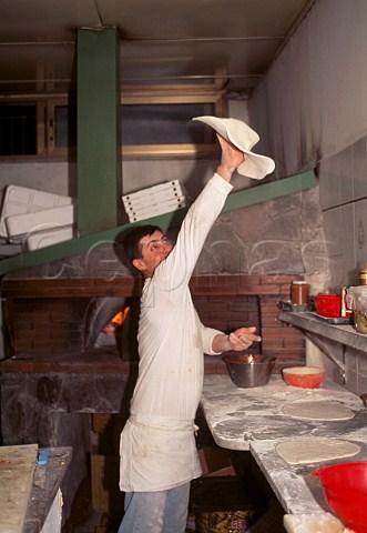 Baker Flinging a pizza base to stretch   it  Naples Italy