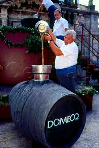 Pouring the freshlytrodden juice into a   barrel during the Festival of the Grape   Jerez de la Frontera Andaluca Spain   Sherry