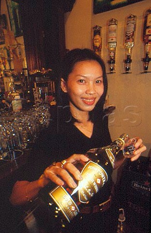 Barmaid serving a shot of whiskey at an Irish  theme pub Saigon Vietnam