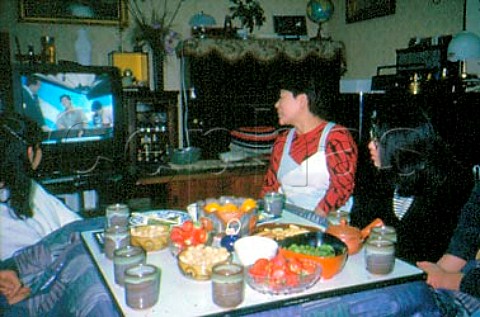 Japanese family watching television   with typical snacks on the kotatsu table   Peanuts green beans strawberries   satsuma oranges and biscuits  Nagano   city Nagano Prefecture Japan