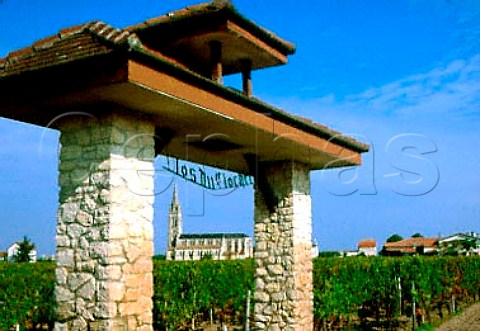 Stone arch in Clos du Clocher vineyard   with Pomerol church beyond Gironde   France     Pomerol  Bordeaux