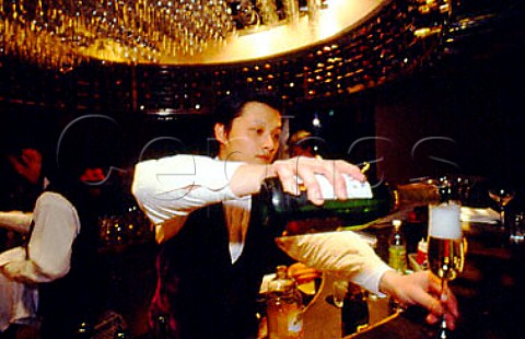 Barman pouring sparkling wine in trendy   wine bar Shanghai China
