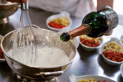 Whisking cream and champagne with bowls of white  red strawberries  Reims France