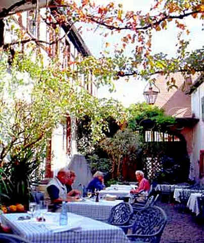 People dining in the courtyard of Weinhaus Henninger   restaurant Kallstadt Pfalz Germany