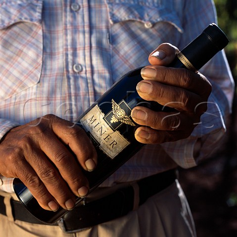 Hands holding bottle of Miner Family   Cabernet Sauvignon    Oakville Napa Co California