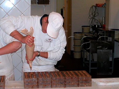 Making traditional handmade Belgian chocolates in   Pralinette Wollestraat Bruges Belgium