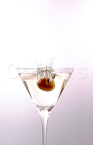 Dropping an olive into a Dry Martini