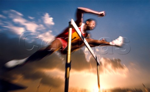 Runner clearing hurdle against blue sky at sunset   Radial Blur applied