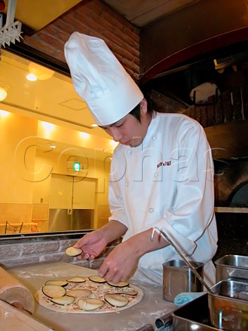 Chef preparing an aubergine pizza in an Italian   style restaurant  Tokyo Japan
