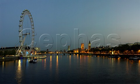 London Eye observation wheel at dusk overlooking   the Parliament buildings and River Thames London