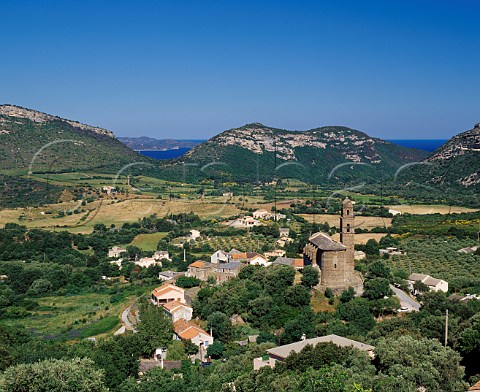 View over the village and church of Patrimonio with the Golfe de StFlorent visible between the hills   HauteCorse Corsica France   AC Patrimonio