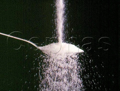 Pouring white sugar on to a spoon