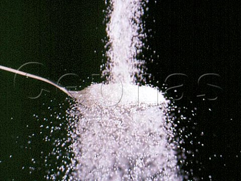 Pouring white sugar on to a spoon
