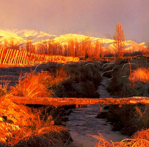 Irrigation channel in Adrianna vineyard of Catena   Zapata at an altitude of around 1500 metres with   the Andes beyond Gualtallary Mendoza Argentina     Tupungato