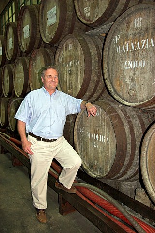 John Cossart chairman of Henriques  Henriques   standing against barrels of Madeira wine maturing in   their cellars Ribeira do Escrivao Quinta Grande   Madeira Portugal