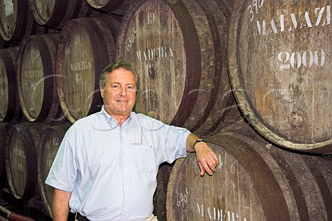 John Cossart chairman of Henriques  Henriques   standing against barrels of Madeira wine maturing in   their cellars Ribeira do Escrivao Quinta Grande   Madeira Portugal