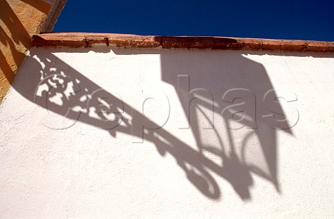 Shadow of a street lamp cast on an Andalucian   whitewashed wall  Spain